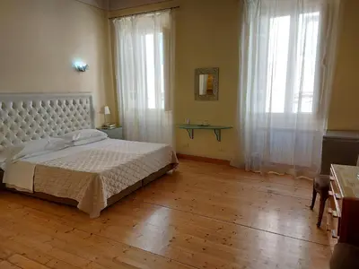 a bedroom with a white bed and a wooden floor at Residenza Al Corso Suites in Rome