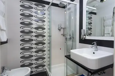 a bathroom with a sink and a glass shower at Noba Hotel e Residenze in Rome