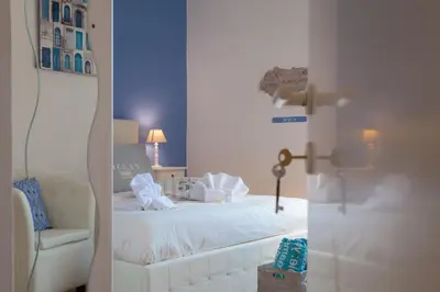 a bedroom with a white bed and a chair at Boutique Domus Trastevere Vascellari in Rome
