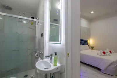a bathroom with a sink and a shower and a bed at Miss Suite in Rome