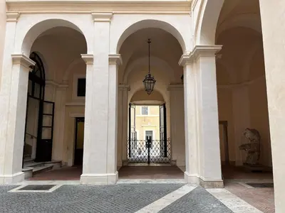 a hallway of a building with columns and a chandelier at Lovatelli Home al Campidoglio in Rome