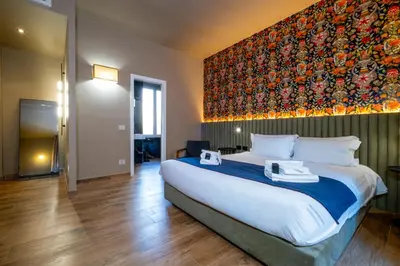 a bedroom with a large bed with a large painting on the wall at HT Residence Maximus in Rome