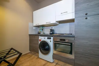 a kitchen with a washing machine and a washer at HT Residence Maximus in Rome