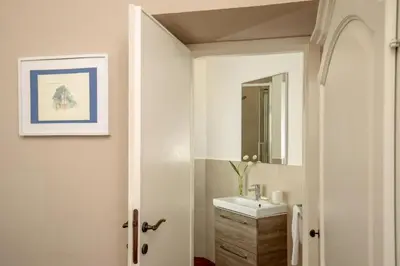 a white bathroom with a sink and a mirror at Avignonesi Suites - CA Domus Collection in Rome