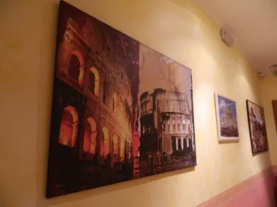 a painting of a building hanging on a wall at Legends in Rome