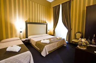 a hotel room with two beds and a window at Nice Rome Holiday in Rome