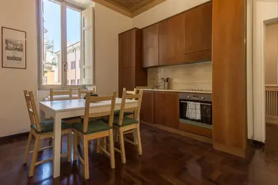 a kitchen with a table and chairs and a stove at GuestHost - Palazzo Borghese Lovely Flat in Rome