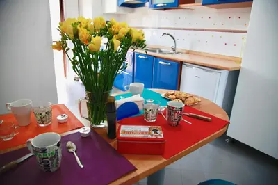 a kitchen with a table with a vase of flowers at Casa Vacanza Marrucini in Rome