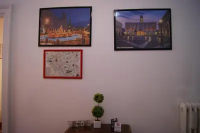 three pictures hanging on a wall with a table at Tatusa al Colosseo in Rome