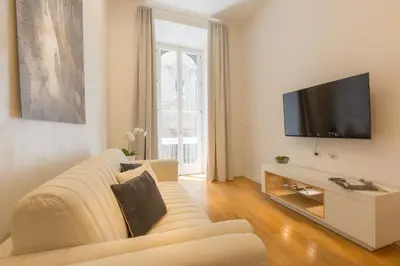 a living room with a couch and a flat screen tv at Amazing Piazza Venezia Suites in Rome