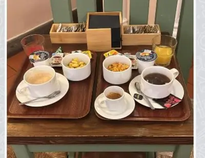 a table with cups of coffee and bowls of food at Hotel Panda in Rome
