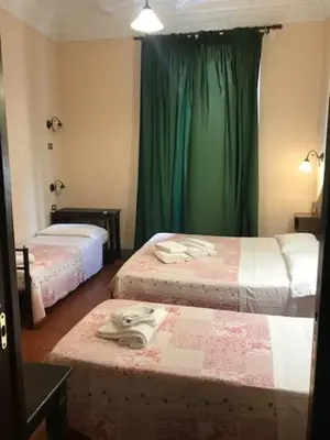 a hotel room with two beds with green curtains at Hotel Panda in Rome