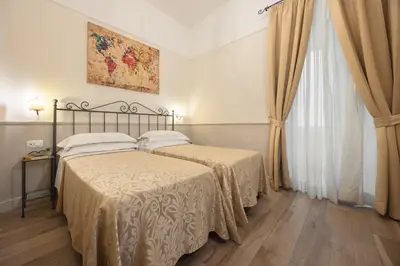 a bedroom with two beds and a window at Hotel Flavia in Rome
