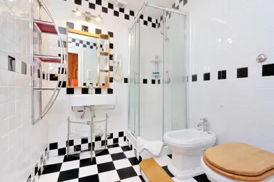 a bathroom with a toilet and a glass shower at Sonnino Suite in Rome