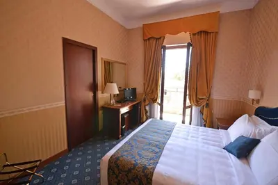 a hotel room with a bed and a window at Hotel Cilicia in Rome