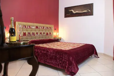 a bedroom with a bed and a table with a bottle of wine at Lorenz Suites Trastevere Hill in Rome