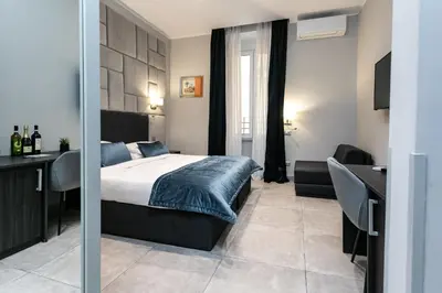 a bedroom with a bed and a desk and a desk at Cesare ai Cavalieri Suites in Rome