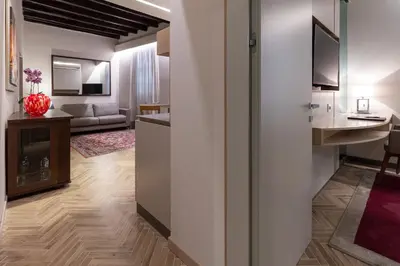 a living room with a kitchen and a living room with a couch at Harry's Bar Trevi Luxury Apartments - Modelli in Rome