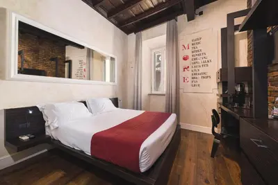 a bedroom with a bed and a dresser in it at Relais 88 in Rome