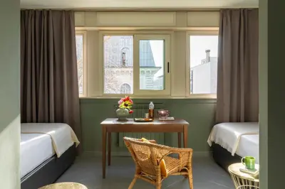 a room with a table and two beds and a window at Hotel Marisa in Rome