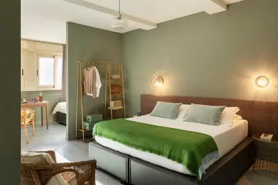 a bedroom with a large bed with a green blanket at Hotel Marisa in Rome