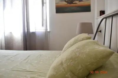 a bed with white sheets and pillows on it at Trastevere St. Garden House in Rome