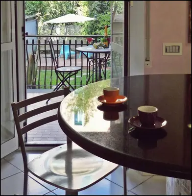 a table with two cups on top of it on a balcony at Trastevere St. Garden House in Rome
