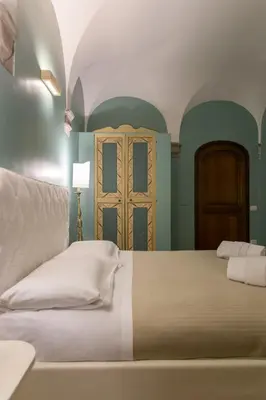 a bedroom with a white bed and a door at Navona apartment in Rome