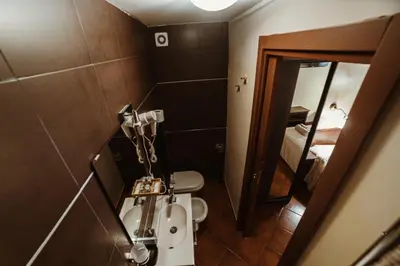 a bathroom with a toilet and a sink and a mirror at Ronda St. Angelo Suites in Rome