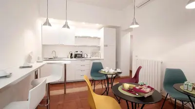 a kitchen and dining room with chairs and a table at Domus Iuliae in Rome