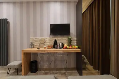 a table with chairs and a television in a room at Relais Barberini in Rome
