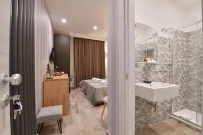 a bathroom with a sink and a bedroom with a bed at Relais Barberini in Rome