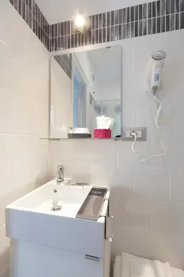 a white bathroom with a sink and a mirror at Pianeta roma 48 in Rome