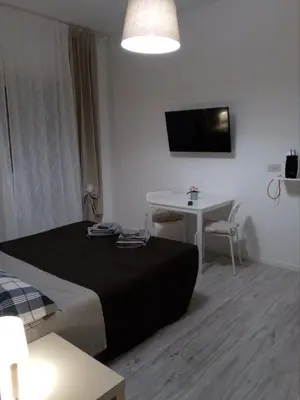 a bedroom with a bed and a table and a tv at Pianeta roma 48 in Rome