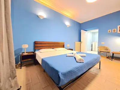 a blue bedroom with a bed with towels on it at Appartamento Tadolini in Rome