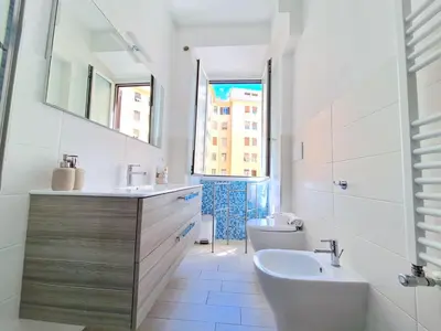 a white bathroom with a sink and a toilet at Appartamento Tadolini in Rome