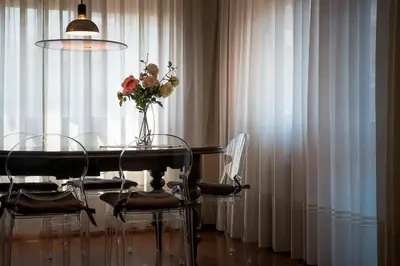 a dining room table with chairs and a vase of flowers at Plumbird Boutique & Apartment in Rome