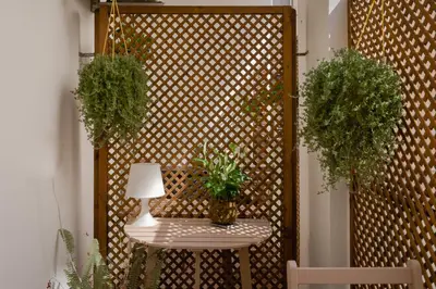 a fence with two potted plants and a table with a lamp at Residenza Il Giglio in Rome