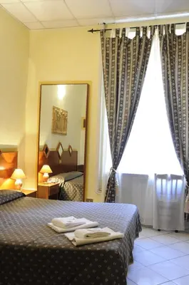 a hotel room with a bed and a mirror at Hotel Farini in Rome