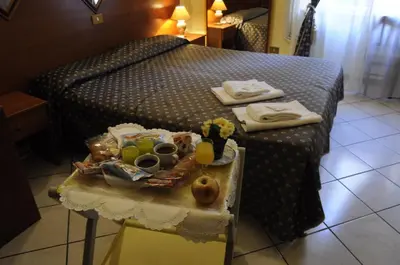 a bed with a table with food and drinks on it at Hotel Farini in Rome