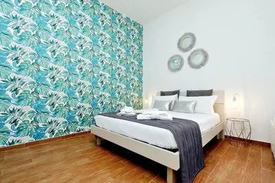 a bedroom with a bed with a blue and white wallpaper at Residenza Musei Vaticani in Rome
