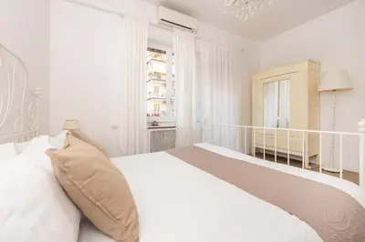 a white bedroom with a large bed and a window at Roma Chic Flat Monte Mario in Rome