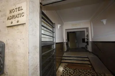 a hotel entrance with a hotelatlantic sign on a wall at Hotel Adriatic in Rome