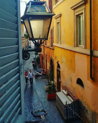 a couple of people walking down a street at Dreaming Navona Rooms in Rome