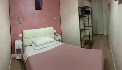 a bedroom with a white bed and a pink wall at Hotel PRINCIPE AMEDEO in Rome