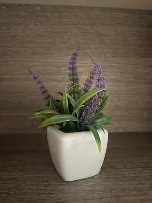 a white vase with purple flowers in it at Casa Rosa in Rome