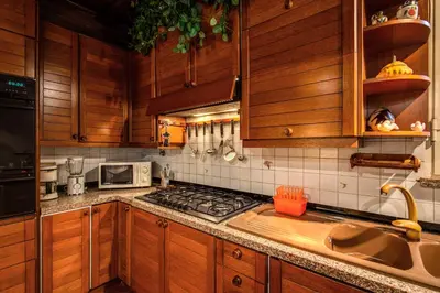 a kitchen with wooden cabinets and a stove top oven at Magenta Collection Egidio in Rome