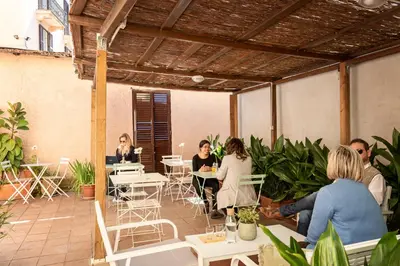 a group of people sitting at tables in a patio at Hotel Parker - Gruppo BLAM HOTELS in Rome
