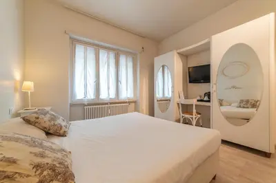 a bedroom with a large white bed and a window at Nina Casetta De Trastevere in Rome