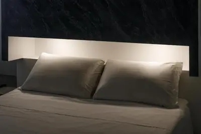 a bed with two pillows and a light above it at Crossroad Hotel in Rome
